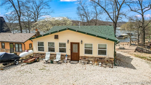 view of front of house with a shingled roof and stone siding
