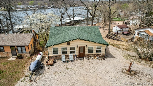 view of front of property featuring stone siding and a shingled roof