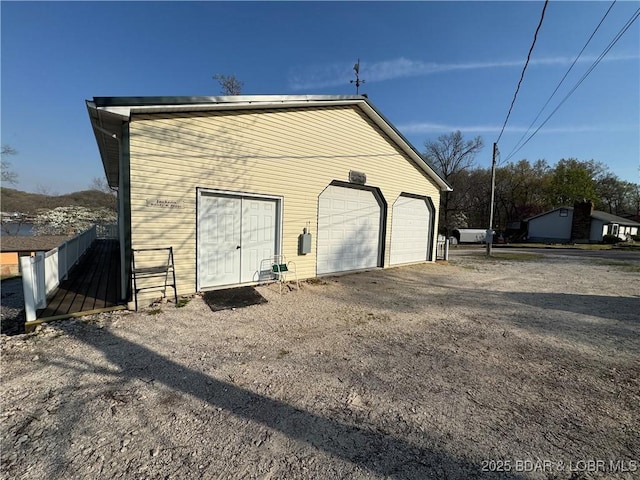 detached garage featuring fence