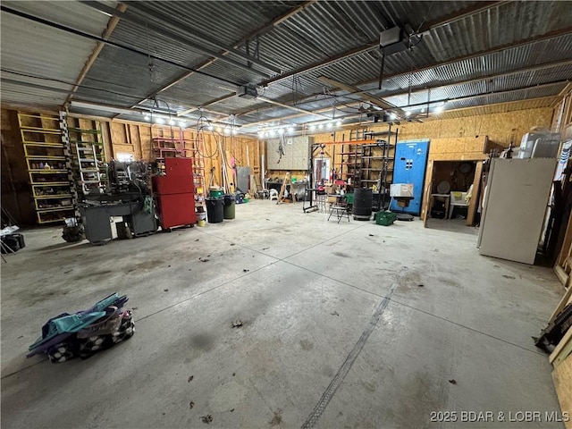garage featuring freestanding refrigerator and a workshop area