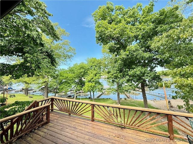 deck with a water view and a yard