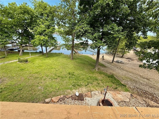 view of green lawn featuring a water view