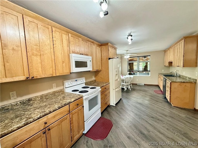kitchen featuring white appliances, a sink, a ceiling fan, dark wood finished floors, and baseboards