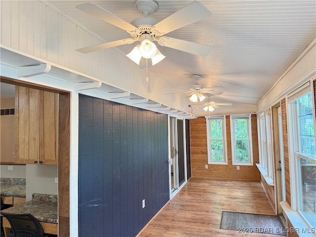 unfurnished sunroom featuring wood finished floors and wood walls