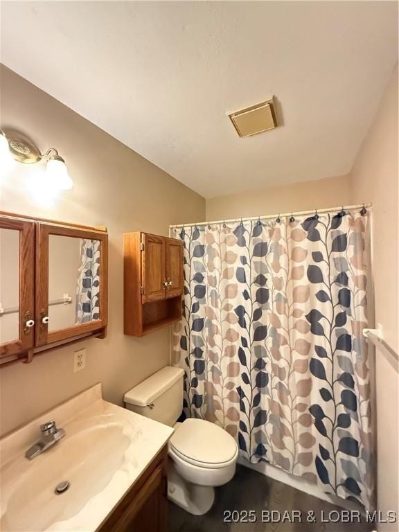 bathroom featuring toilet, vanity, and a shower with shower curtain