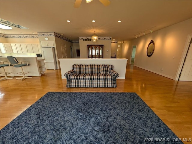 living area featuring baseboards, recessed lighting, rail lighting, a ceiling fan, and light wood finished floors