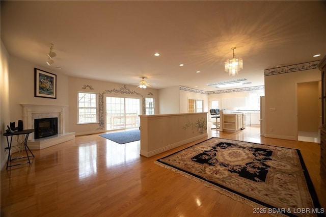 393 Crystal Springs Rd, Linn Creek, MO 65052 - kitchen featuring a fireplace, recessed lighting, wood finished floors, ceiling fan, and a chandelier