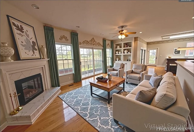 393 Crystal Springs Rd, Linn Creek, MO 65052 - living area with wood finished floors, ceiling fan, a high end fireplace, and recessed lighting