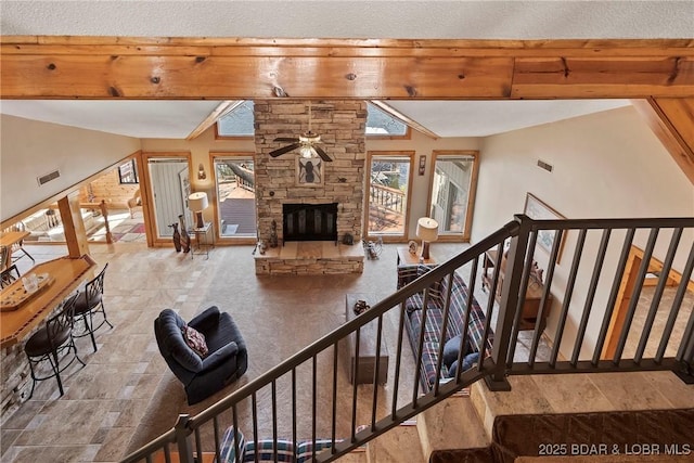 32785 Dixie Dr, Gravois Mills, MO 65037 - stairs featuring a ceiling fan, a stone fireplace, beam ceiling, and baseboards