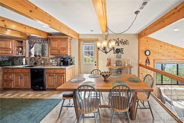 32785 Dixie Dr, Gravois Mills, MO 65037 - dining space featuring healthy amount of natural light, beam ceiling, wooden walls, and a textured ceiling