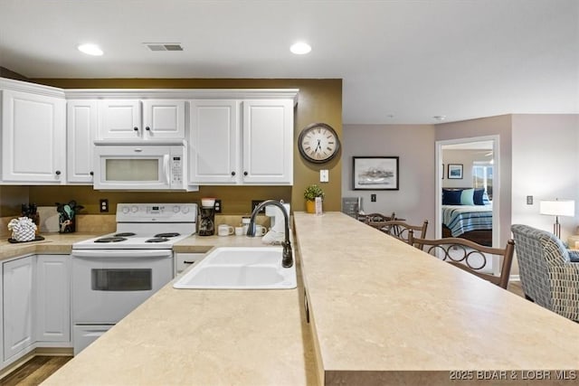67 Cedar Heights Ln Unit 3A, Camdenton, MO 65020 - kitchen with white appliances, a sink, white cabinetry, light countertops, and recessed lighting