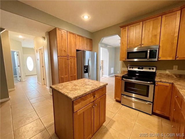 1148 Sweetwater Dr, Four Seasons, MO 65049 - kitchen featuring a kitchen island, stainless steel appliances, arched walkways, and light tile patterned floors