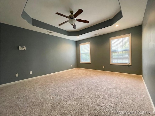 1148 Sweetwater Dr, Four Seasons, MO 65049 - carpeted spare room with visible vents, a ceiling fan, baseboards, and a tray ceiling