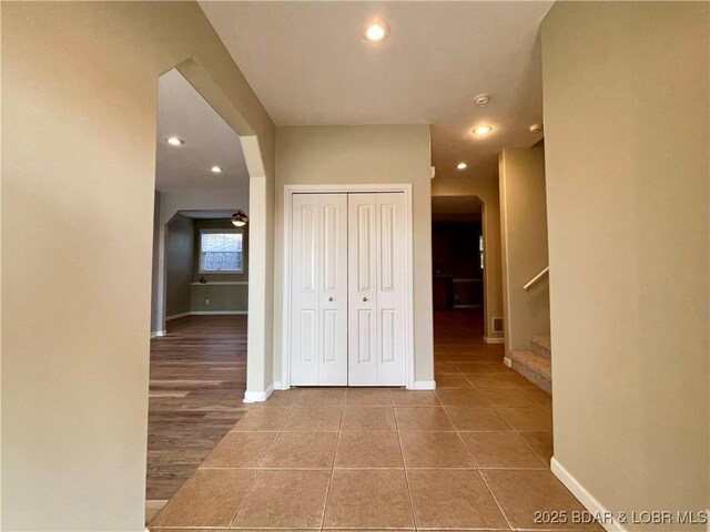1148 Sweetwater Dr, Four Seasons, MO 65049 - corridor featuring stairs, arched walkways, baseboards, and tile patterned flooring