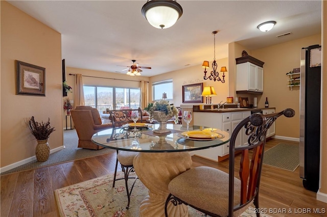 275 Flynn Rd Unit 205, Lake Ozark, MO 65049 - dining space featuring visible vents, baseboards, a ceiling fan, and wood finished floors