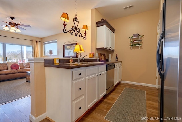 275 Flynn Rd Unit 205, Lake Ozark, MO 65049 - kitchen with visible vents, open floor plan, freestanding refrigerator, a peninsula, and stainless steel dishwasher