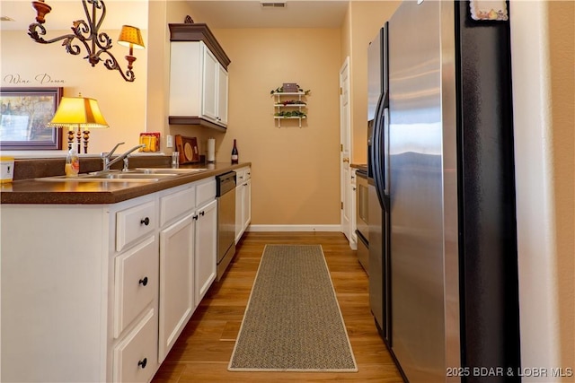 275 Flynn Rd Unit 205, Lake Ozark, MO 65049 - kitchen featuring dark countertops, light wood-style flooring, dishwasher, and refrigerator with ice dispenser