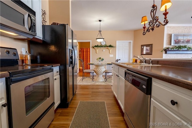 275 Flynn Rd Unit 205, Lake Ozark, MO 65049 - kitchen featuring pendant lighting, white cabinets, appliances with stainless steel finishes, a sink, and dark countertops