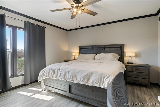 bedroom with ornamental molding, wood finished floors, baseboards, and ceiling fan