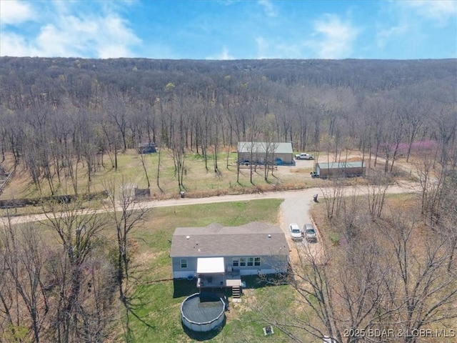 view of subject property with a heavily wooded area