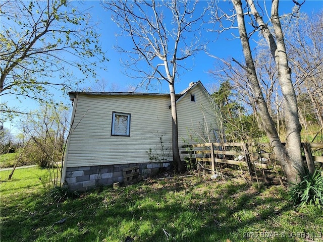view of property exterior featuring a yard and fence