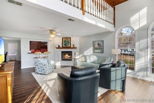 living room with a ceiling fan, wood finished floors, and visible vents