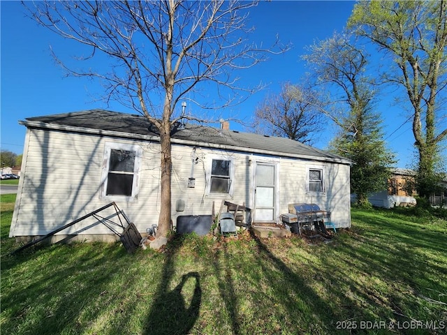 back of property featuring a lawn and a chimney
