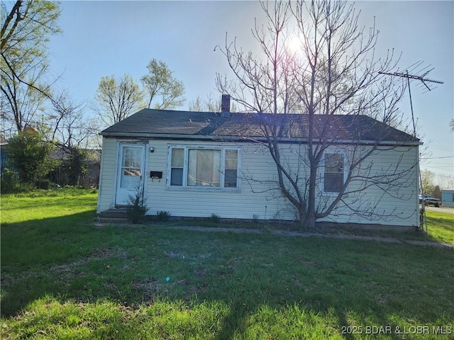 view of front of property with a front yard and a chimney