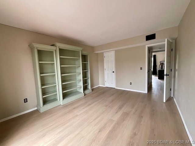 unfurnished room with visible vents, baseboards, and wood finished floors