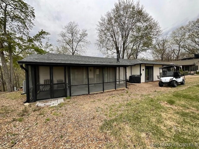 rear view of property with a sunroom and a lawn