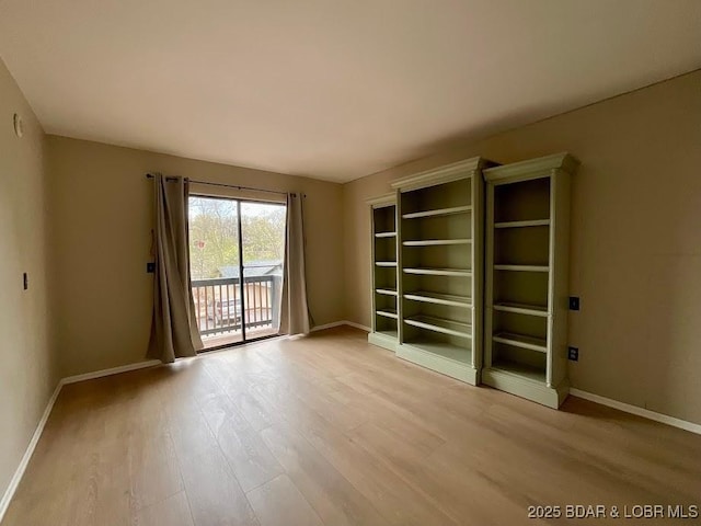 spare room featuring wood finished floors and baseboards