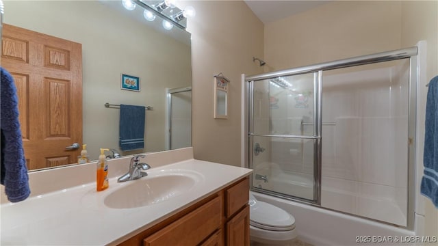 bathroom featuring toilet, vanity, and bath / shower combo with glass door