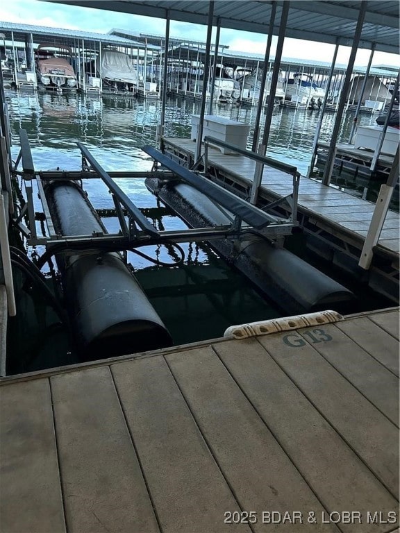 dock area with boat lift and a water view