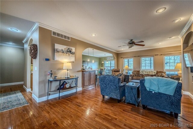 living area with visible vents, baseboards, arched walkways, a ceiling fan, and hardwood / wood-style floors