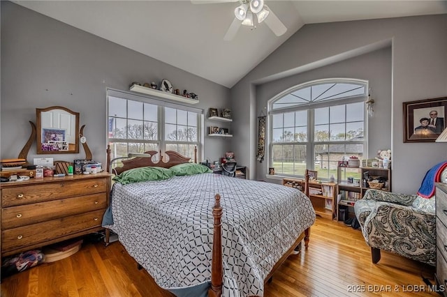 bedroom featuring wood finished floors, high vaulted ceiling, and a ceiling fan