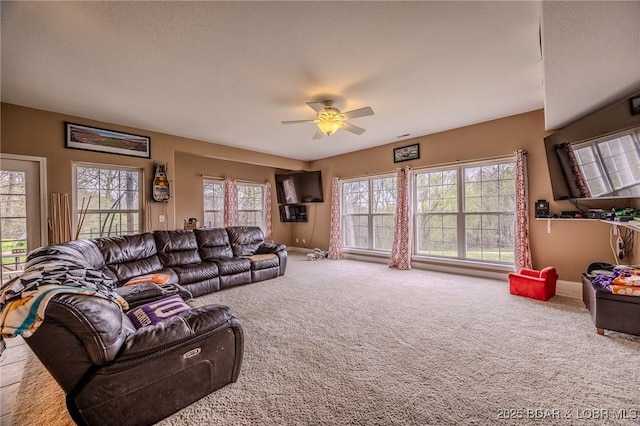 living room with carpet, baseboards, and ceiling fan