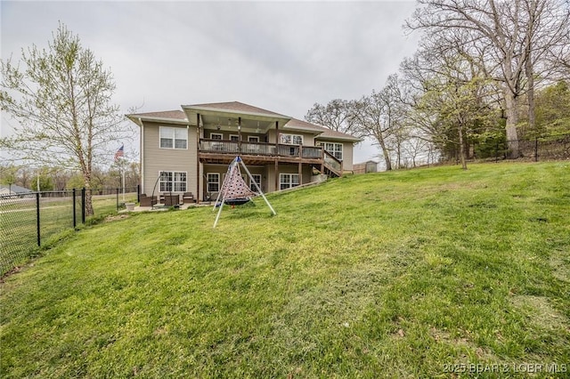 rear view of property with stairway, a deck, a fenced backyard, and a lawn