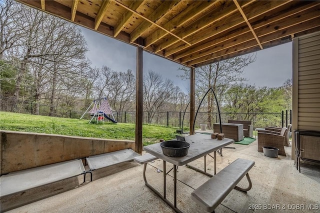 view of patio with a fenced backyard, a playground, and an outdoor fire pit