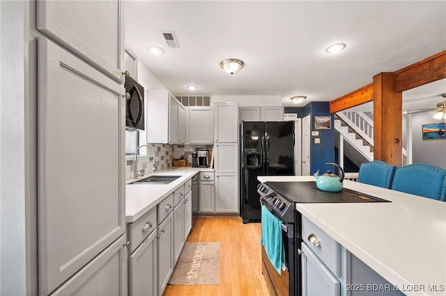 70 Ravenwood Dr, Lake Ozark, MO 65049 - kitchen featuring black appliances, light wood-style flooring, light countertops, tasteful backsplash, and gray cabinets