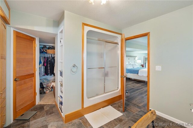 14671 Old Marvin Rd, Versailles, MO 65084 - bathroom featuring a stall shower, ensuite bathroom, baseboards, and stone finish flooring