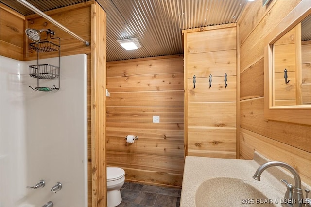14671 Old Marvin Rd, Versailles, MO 65084 - bathroom with wood walls, toilet, stone finish floor, and vanity