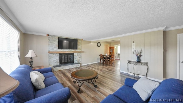 160 Bridgeview Dr, Camdenton, MO 65020 - living area featuring ornamental molding, a textured ceiling, a large fireplace, and wood finished floors