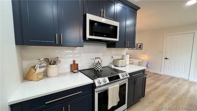 kitchen featuring white microwave, electric range, backsplash, and light wood-style floors