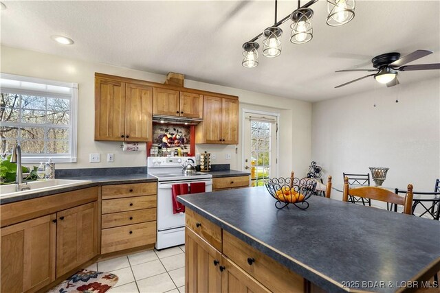 kitchen featuring brown cabinets, light tile patterned flooring, dark countertops, a sink, and white range with electric cooktop