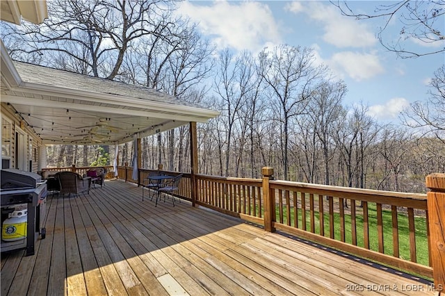 wooden terrace featuring a ceiling fan and a grill