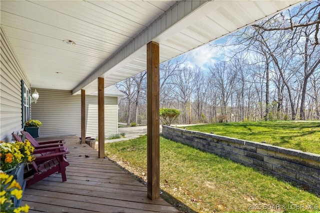 wooden terrace with a lawn and a porch
