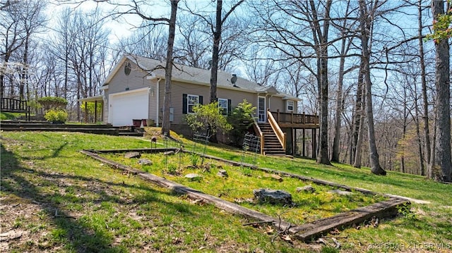 exterior space with a garage, a yard, stairway, and a deck