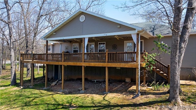 rear view of house with roof with shingles, stairs, a deck, a ceiling fan, and a yard