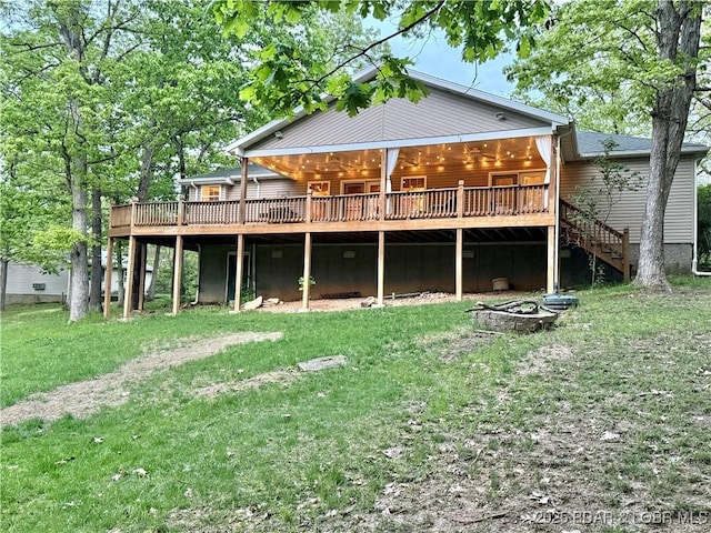 back of property with stairs, a lawn, and a wooden deck