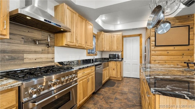 15 Rose Wind Ln, Brumley, MO 65017 - kitchen featuring wall chimney exhaust hood, stainless steel appliances, a sink, dark stone countertops, and light brown cabinetry